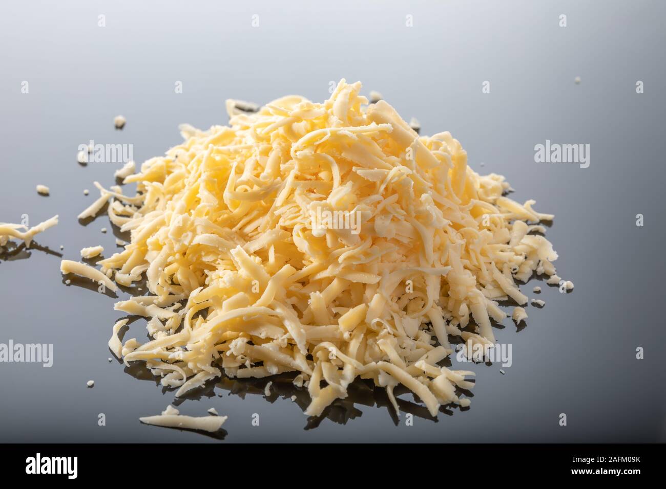 Heap of grated cheese isolated on dark background Stock Photo