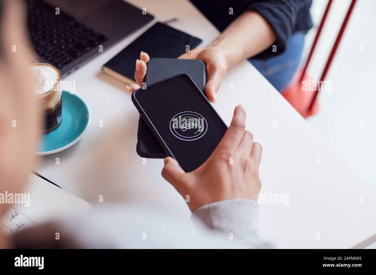 Two Mobiles Phone To Phone Wirelessly Charging On Desk Stock Photo Alamy