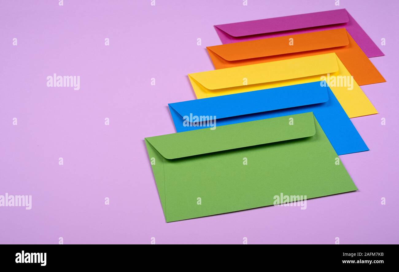 tidy coloured envelopes on a light pink background Stock Photo