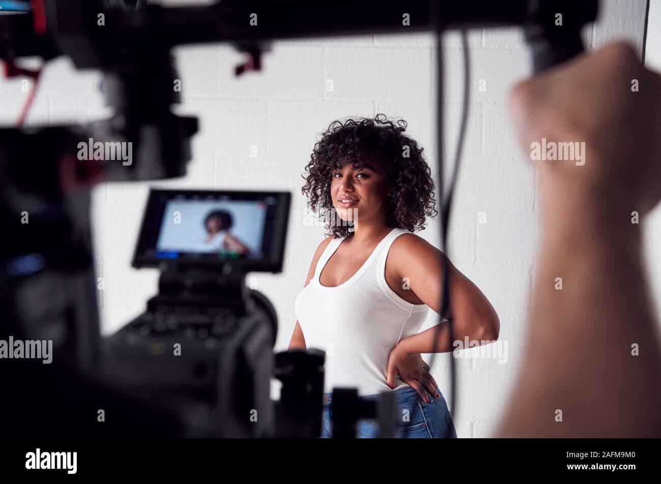 Female Model Posing For Video Camera On Film Set Stock Photo