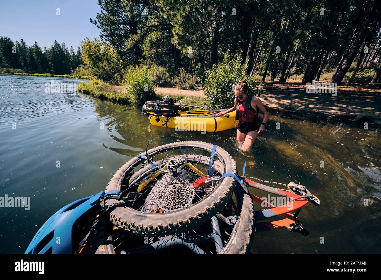 Woman jumps from her pack raft into the Deschutes River to cool off. Stock Photo