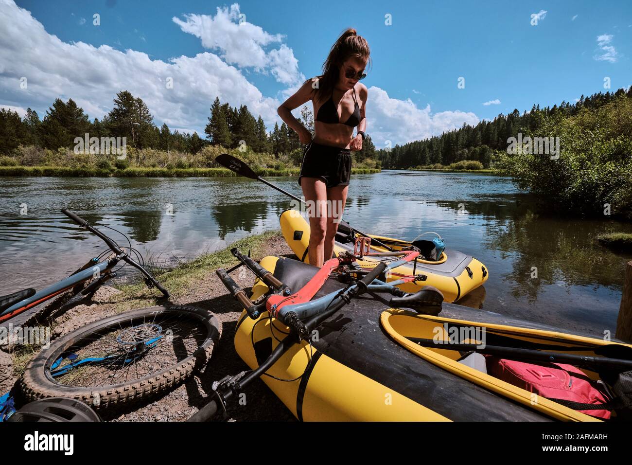 Woman preps her pack raft to float down the Deschutes River in Oregon. Stock Photo