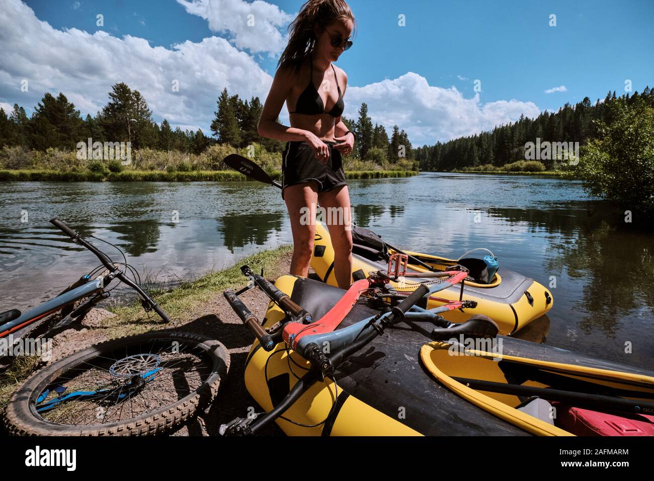 Woman preps her pack raft to float down the Deschutes River in Oregon. Stock Photo