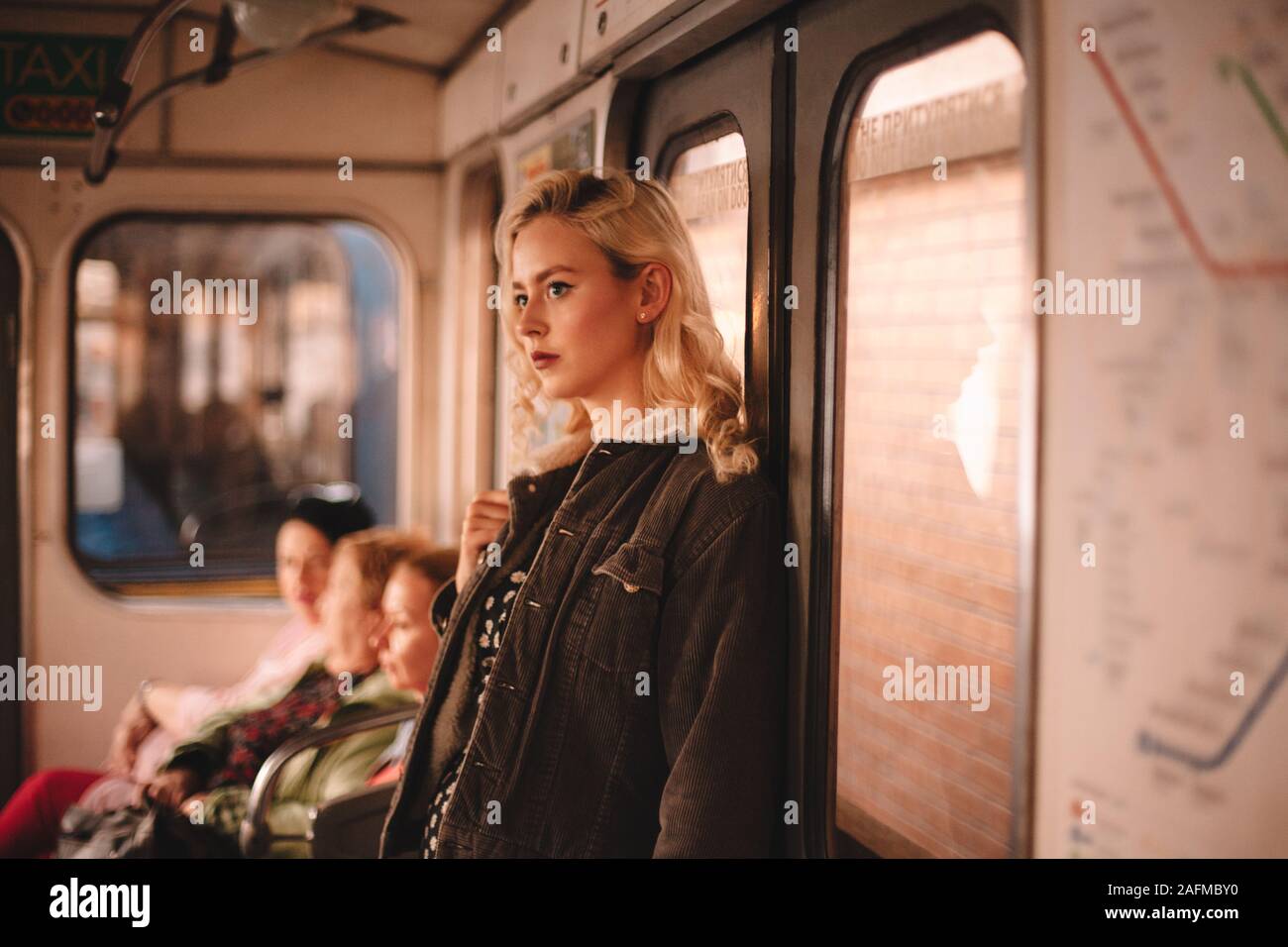 Young thoughtful woman traveling in subway train Stock Photo