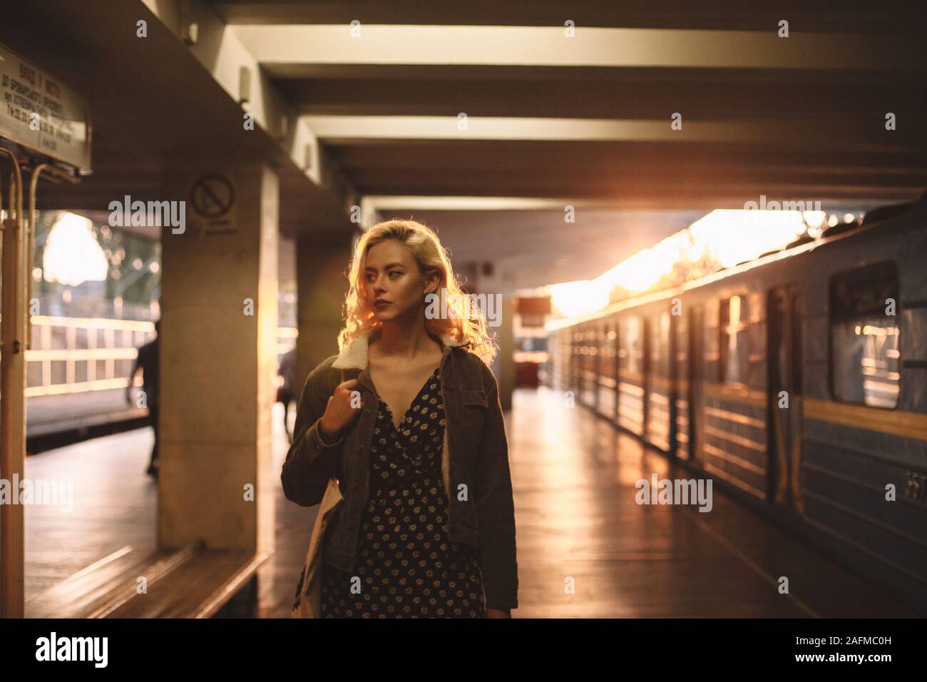 Young tired woman standing on subway train station Stock Photo - Alamy