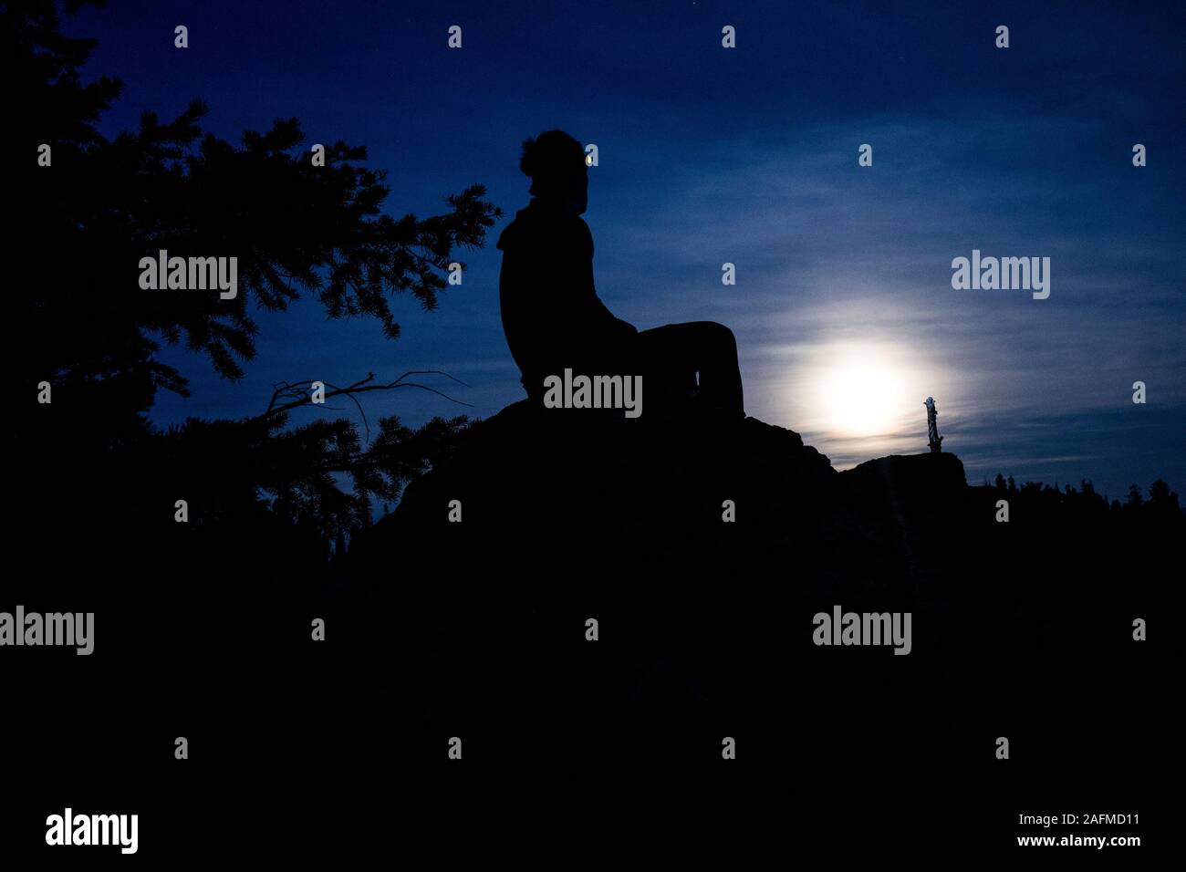 A man watches the moon rise in the Selway Bitterroot Wilderness Stock Photo