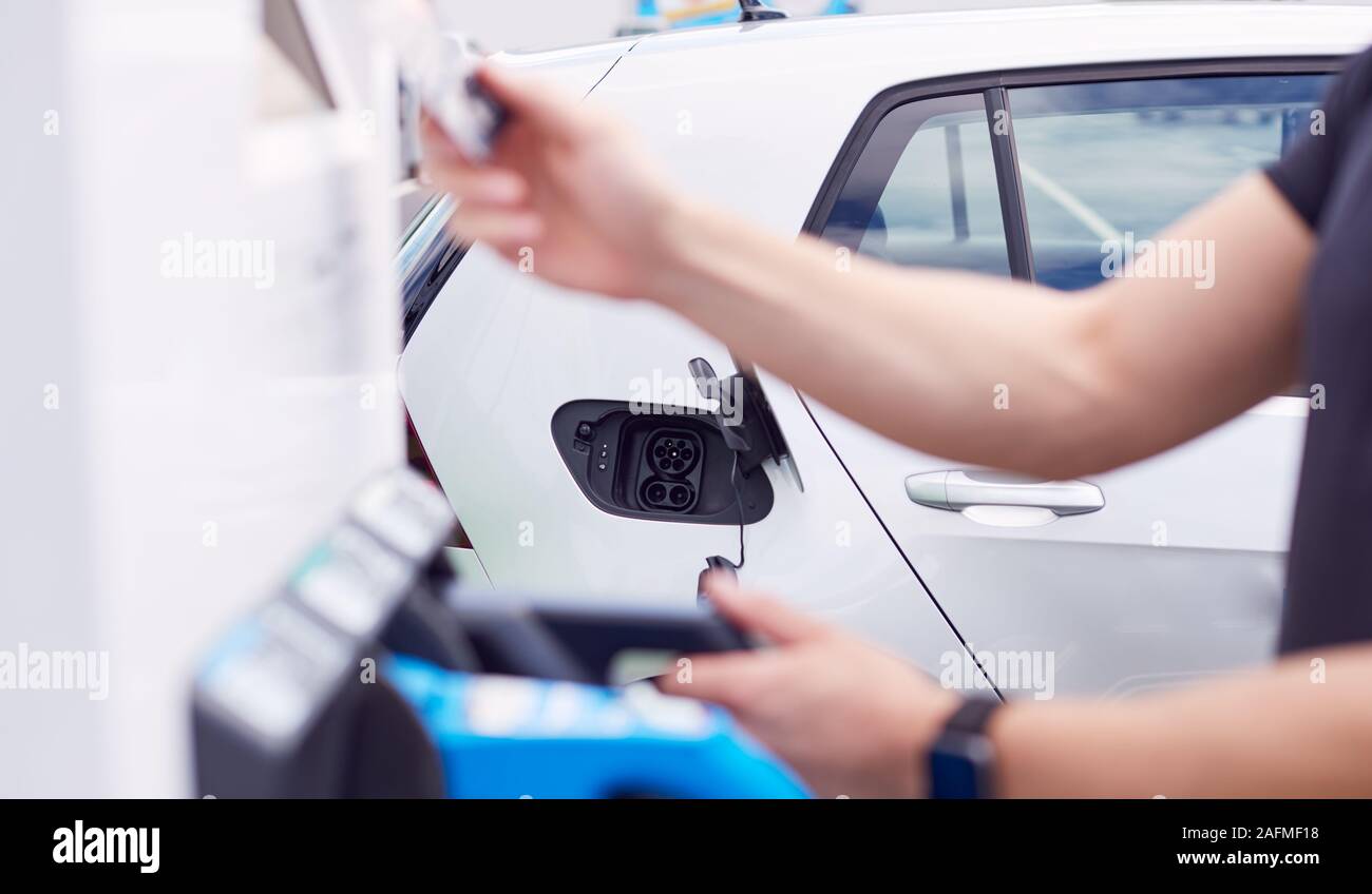 Man charging electric vehicle hires stock photography and images Alamy