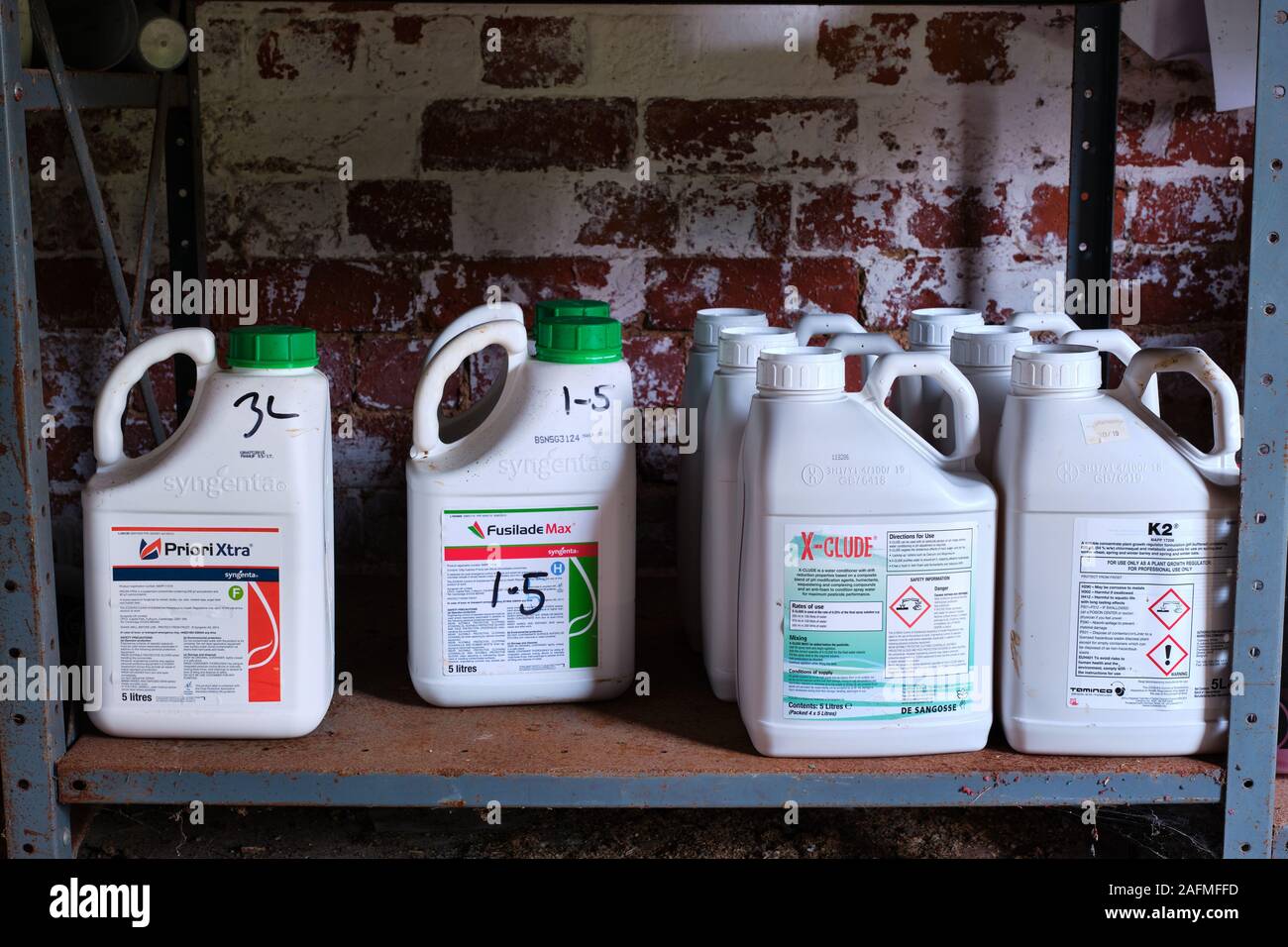 Agrochemicals pesticides on metal shelving in a farm chemical spray store Stock Photo