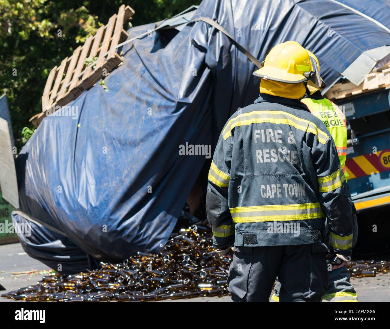 firemen, firefighters, emergency workers, emergency responders at a road accident scene where a truck or lorry has lost its load in Cape Town Stock Photo