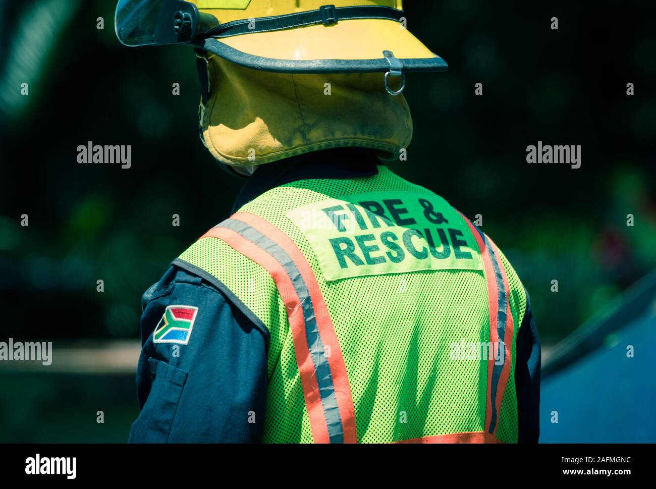 South African fire and rescue services firemen or firefighter wearing uniform, helmet and high visibility clothing at a road accident scene cleanup Stock Photo