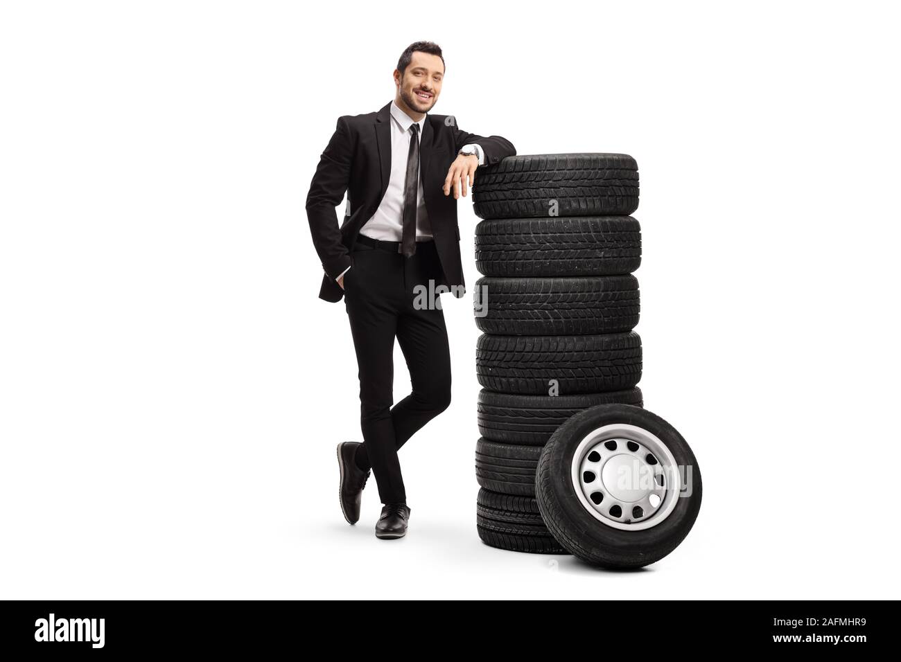Full length portrait of a young businessman leaning on a pile of car