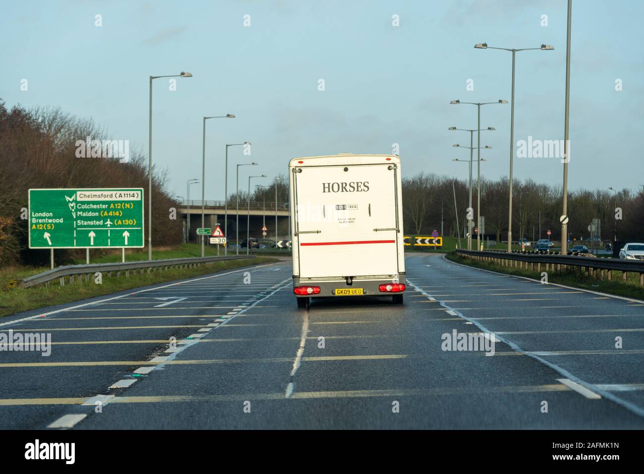 Destination sign with vehicles approaching A12 Chelmsford, Essex, UK driving on a stretch of A130 duel carriageway. Horse box Stock Photo