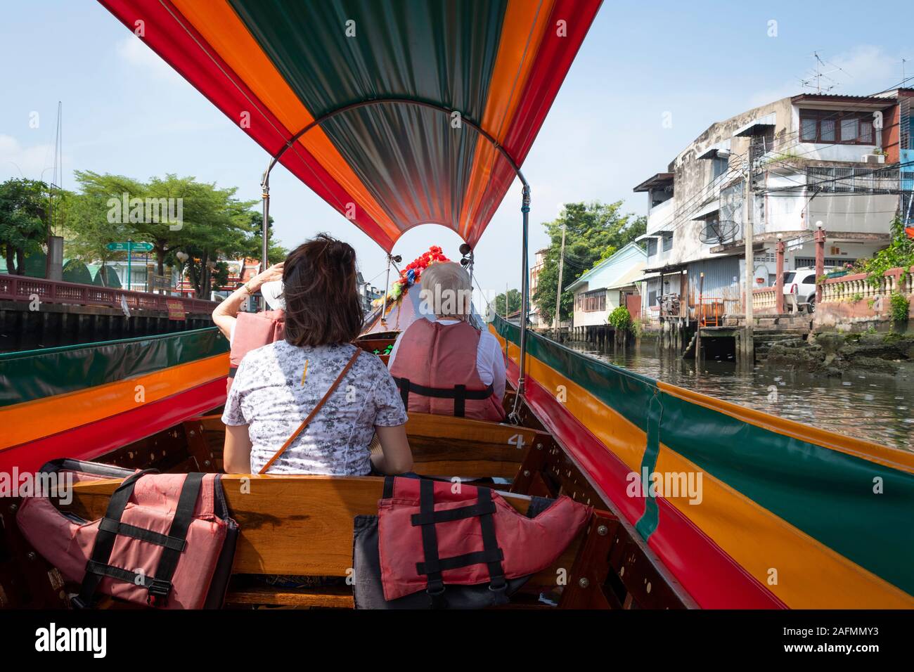 Tourists on Long-tail boat in canal, Bangkok, Thailand Stock Photo