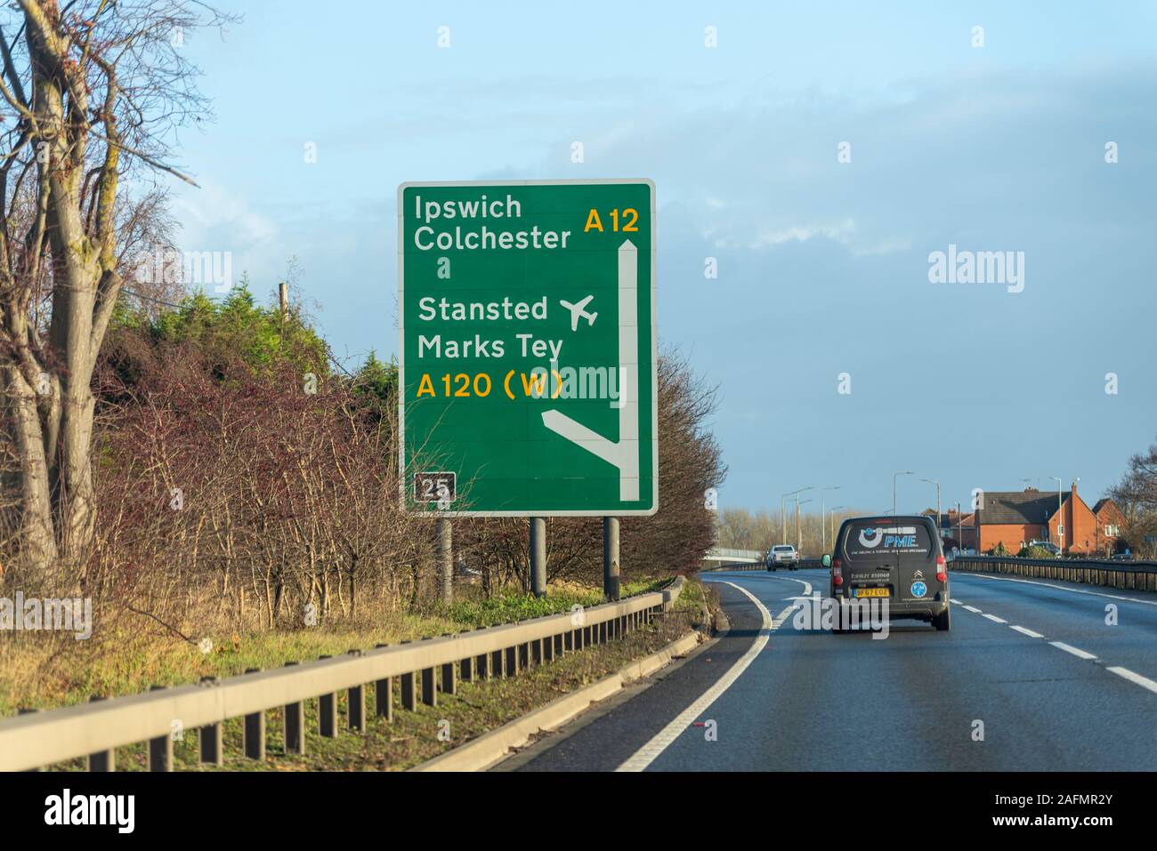 Direction sign for Ipswich, Colchester, Stansted airport, Marks Tey, A120 with vehicles driving on a stretch of A12 duel carriageway, Essex, UK. Stock Photo