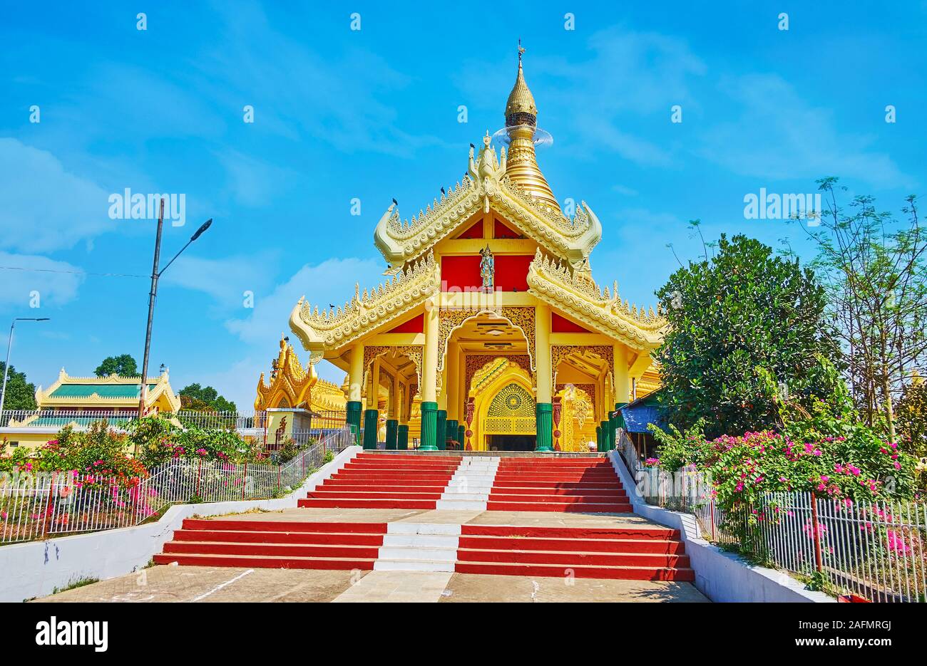 The entrance gate of stunning Mahavijaya (Maha Wizaya) Pagoda with carved bargeboards of multitired (pyathat) roof, Yangon, Myanmar Stock Photo
