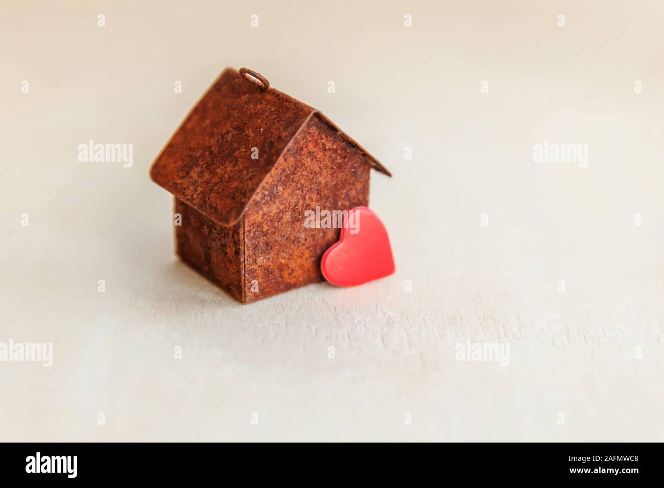Miniature toy model house with red heart on wooden backdrop. Eco Village, abstract environmental background. Real estate mortgage property insurance sweet dream home ecology concept Stock Photo