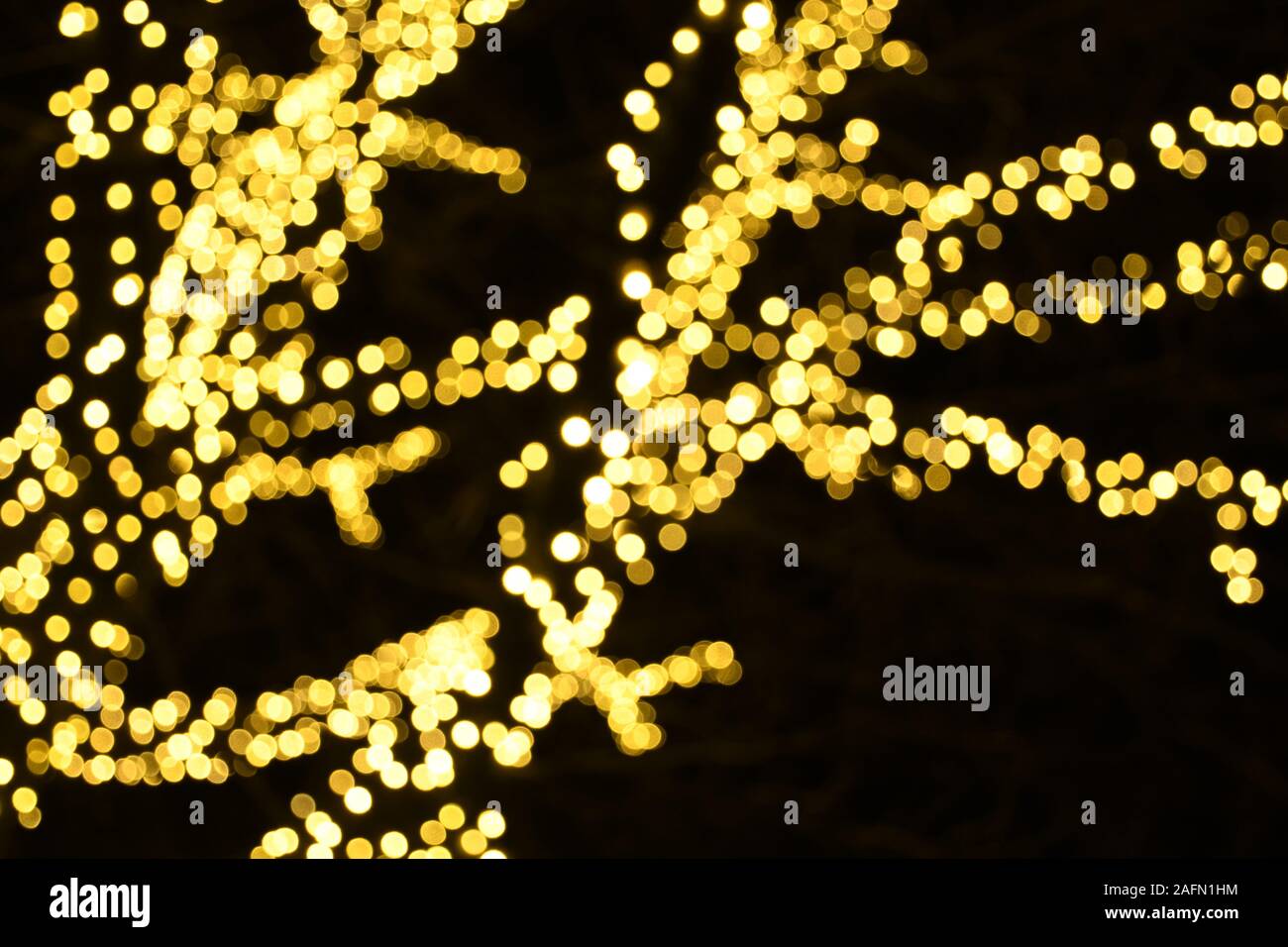 Abstract background yellow golden bokeh lights, branches of a tree in winter, warm feeling, warmth, celebration, magic dream Stock Photo