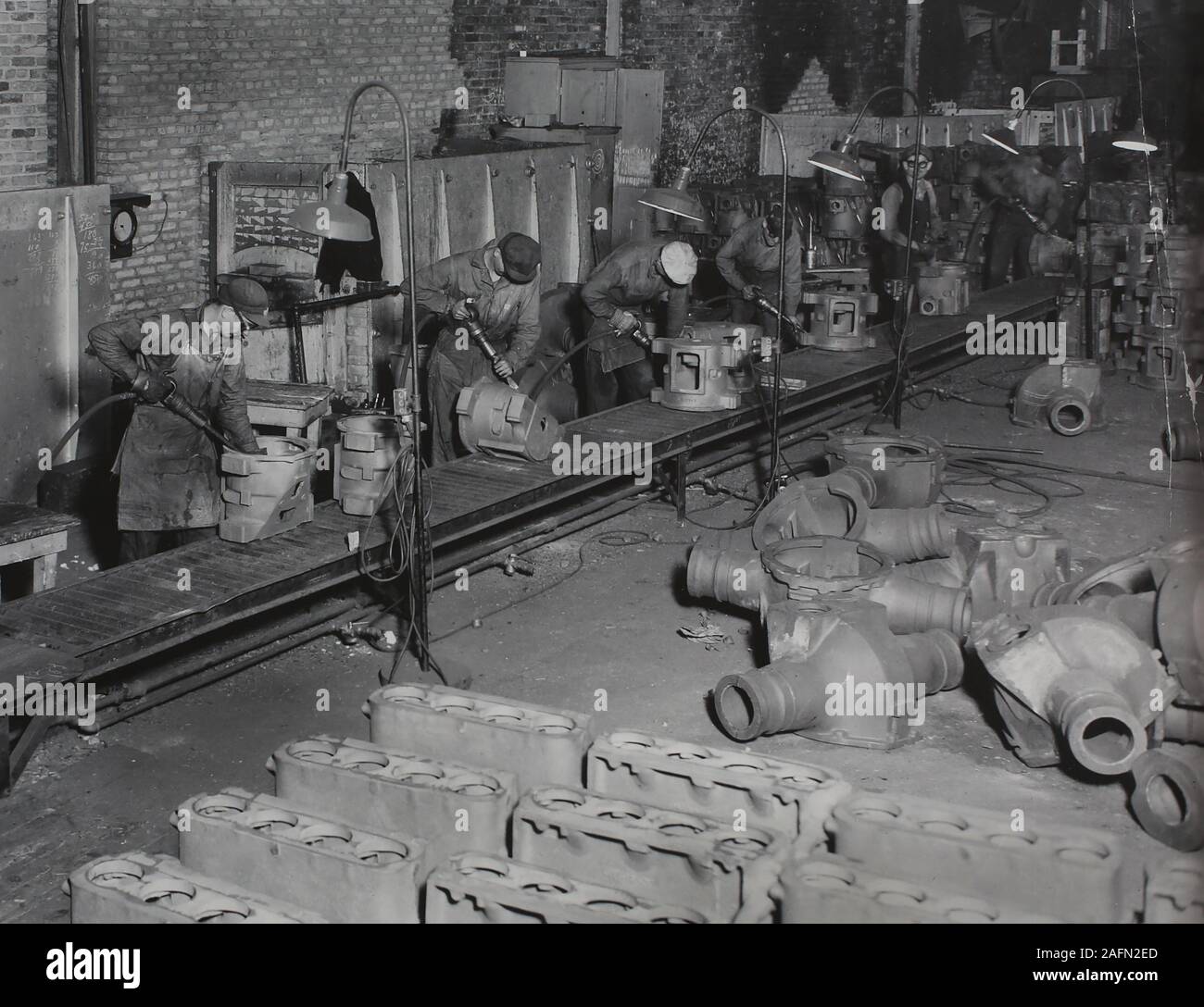 Factory employees work on metal casting at the Allis Chalmers plant in Milwaukee, ca. 1930. Stock Photo