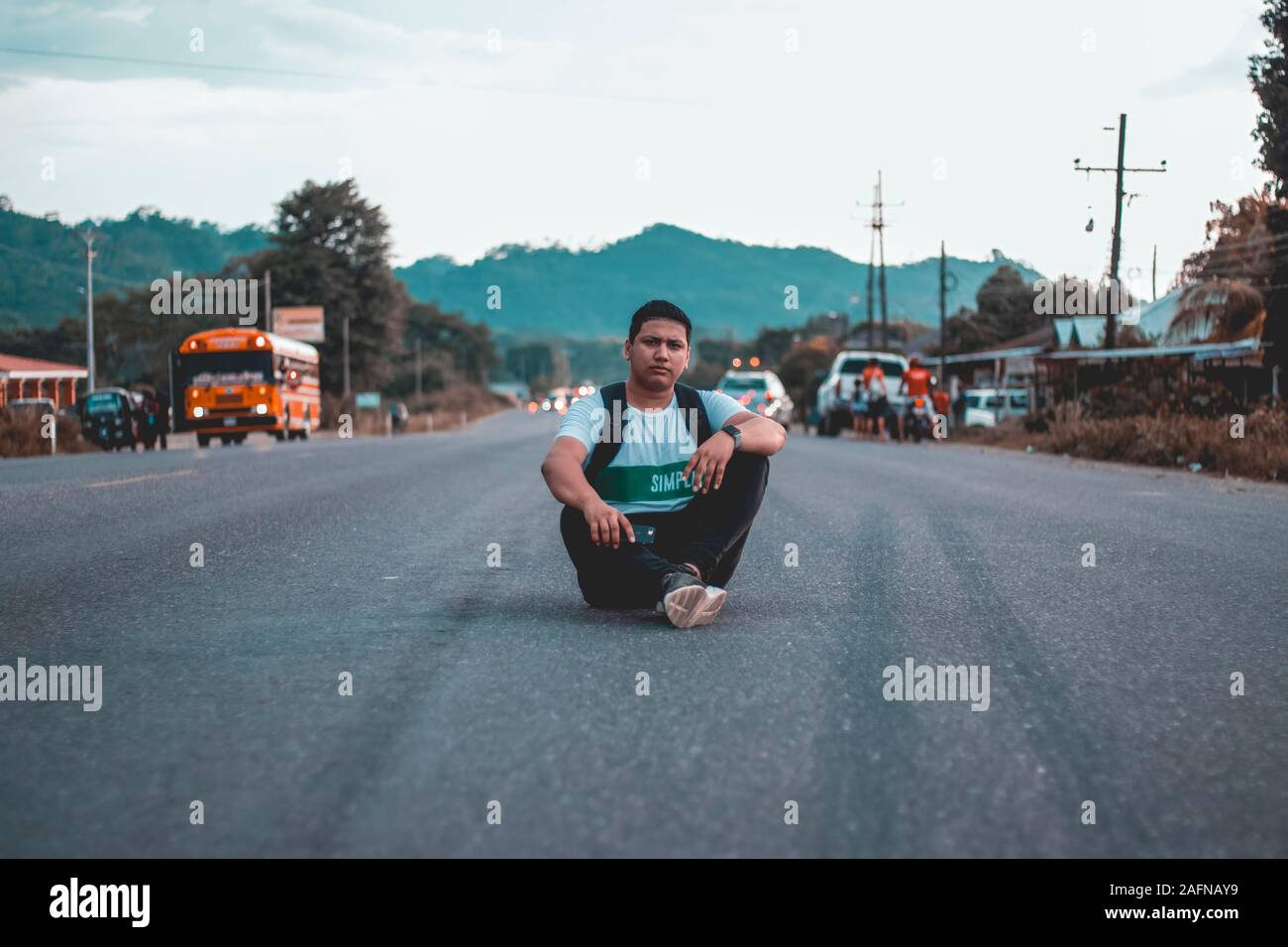 SAN PEDRO SULA, HONDURAS - Dec 08, 2019: Hombre sentado en medio de la carretera, viendo hacia la camara. Stock Photo