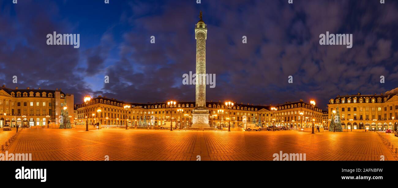 Panoramic view of Place Vendome with Christmas holiday decorations at dusk. In the center, the statue of Napoleon on top of the Vendome column.  Paris Stock Photo