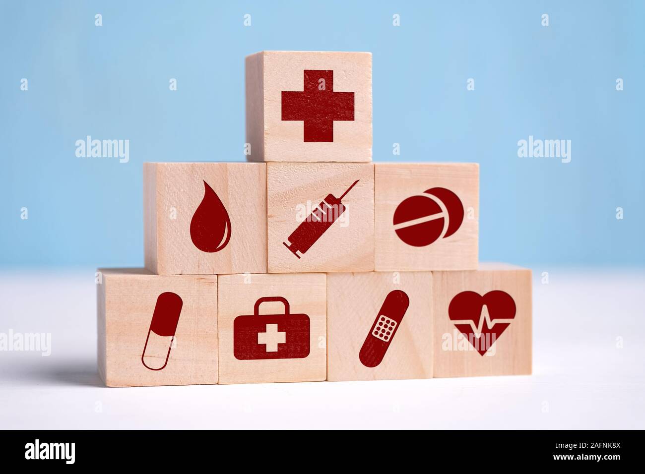 Wooden cubes are icons of icons with honey, analyses, syringe, tablets, pill, band-aid and heart. Close up. Stock Photo