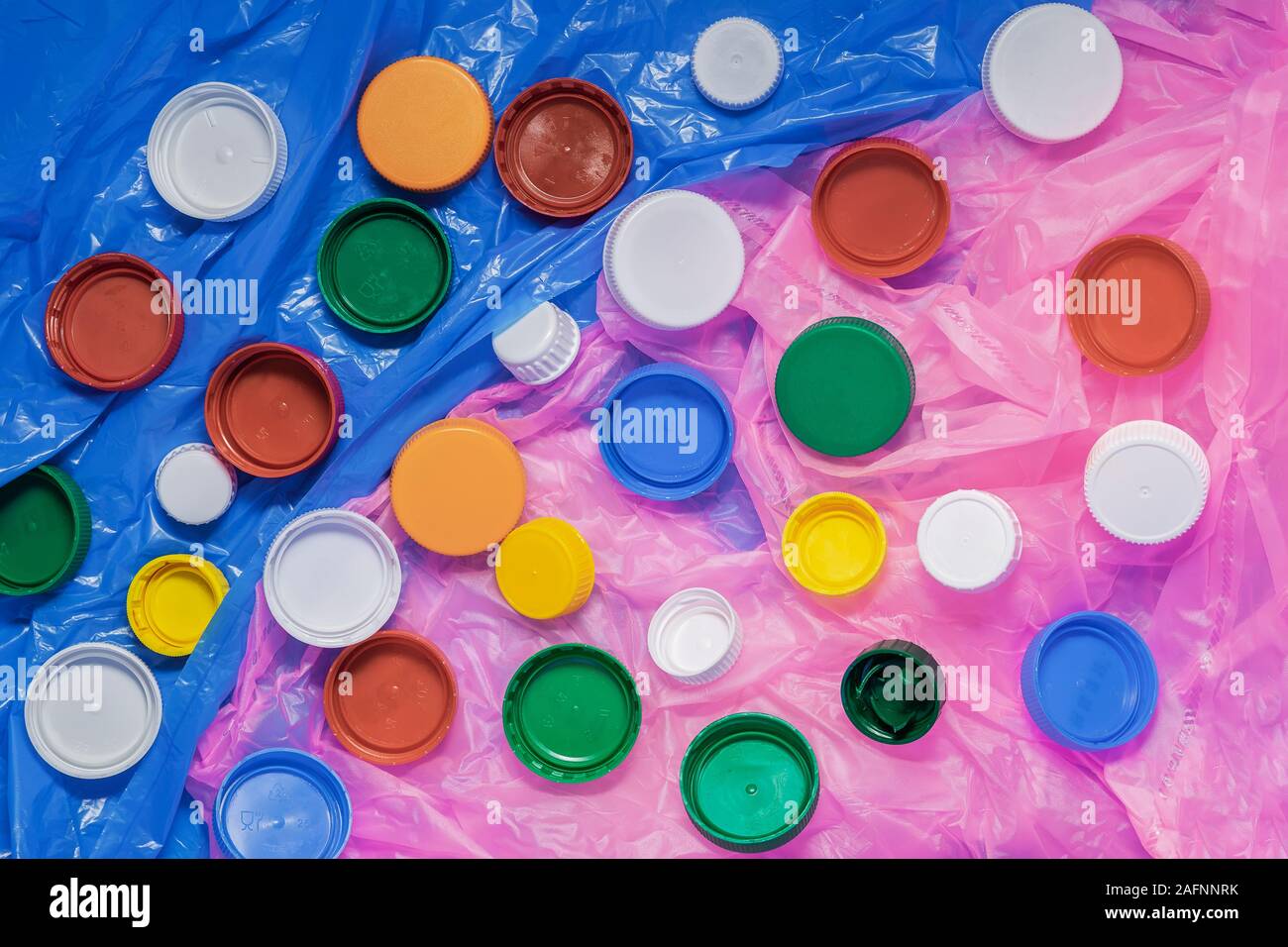 Colored plastic caps ready to be recycled on polyethylene. Concept of