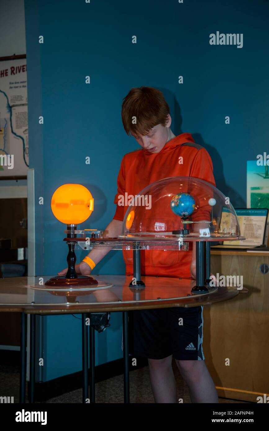 St. Paul, Minnesota.  Science museum of Minnesota.  13 year old boy checks out an exhibit about how the earth and sun work together. Stock Photo