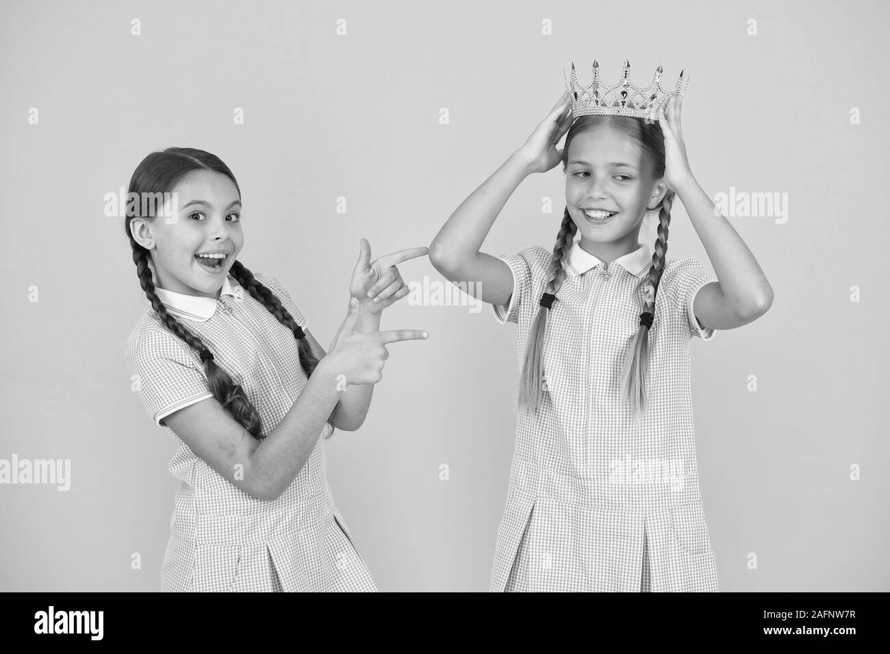 Succeed in education. Celebrating success. She is the best. Happy schoolgirls and golden crown symbol of success. Success and respect. Little princess. Motivational award for school children. Stock Photo