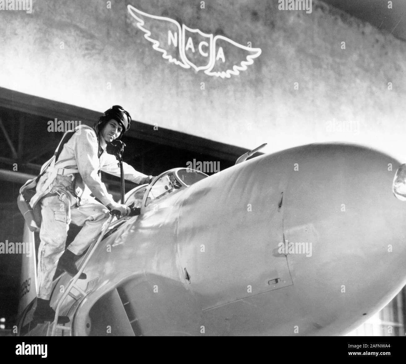 Test pilot Lawrence A. Clousing climbs into his Lockheed P-80 aircraft for a test flight at the Ames Aeronautical Laboratory Stock Photo