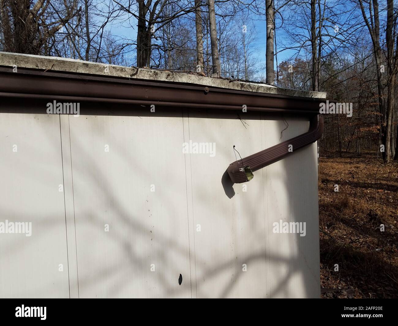 broken gutter downspout on storage shed in forest or woods Stock Photo ...