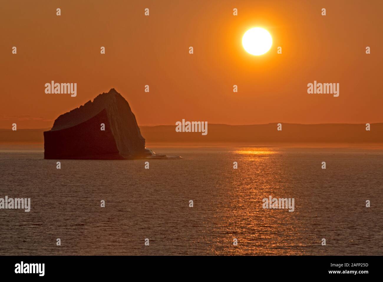 Midnight sun over an iceberg in Scoresby Sund Stock Photo