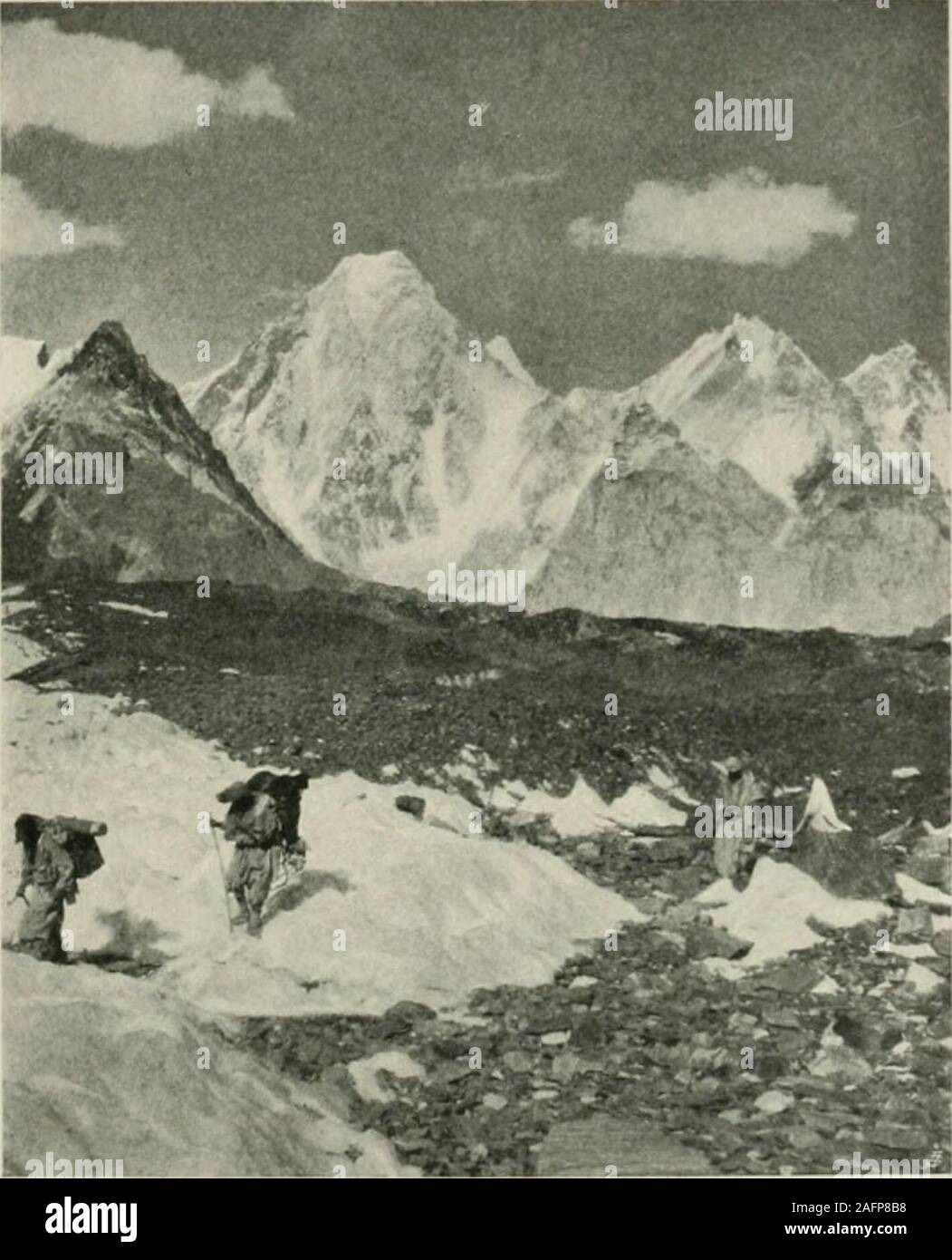 . Karakoram and western Himalaya 1909, an account of the expedition of H. R. H. Prince Luigi Amadeo of Savoy, duke of the Abruzzi. From Rdokass to the Concordia Amphitheatre. 21:3 down in great icefalls from precipices loaded with snow. Then comesMitre Peak, a colossal, strangely-shaped crag, which terminates theleft wall of the valley. In front of us, apparently quite close at hand,the transversal chain of the Gasherbrum seeias to shut in the valley.It is a file of peaks and snow crests, stretching on both sides of theprecipitous rock wall of the Gasherbrum itsolf, all ridges and ice guUies,. Stock Photo