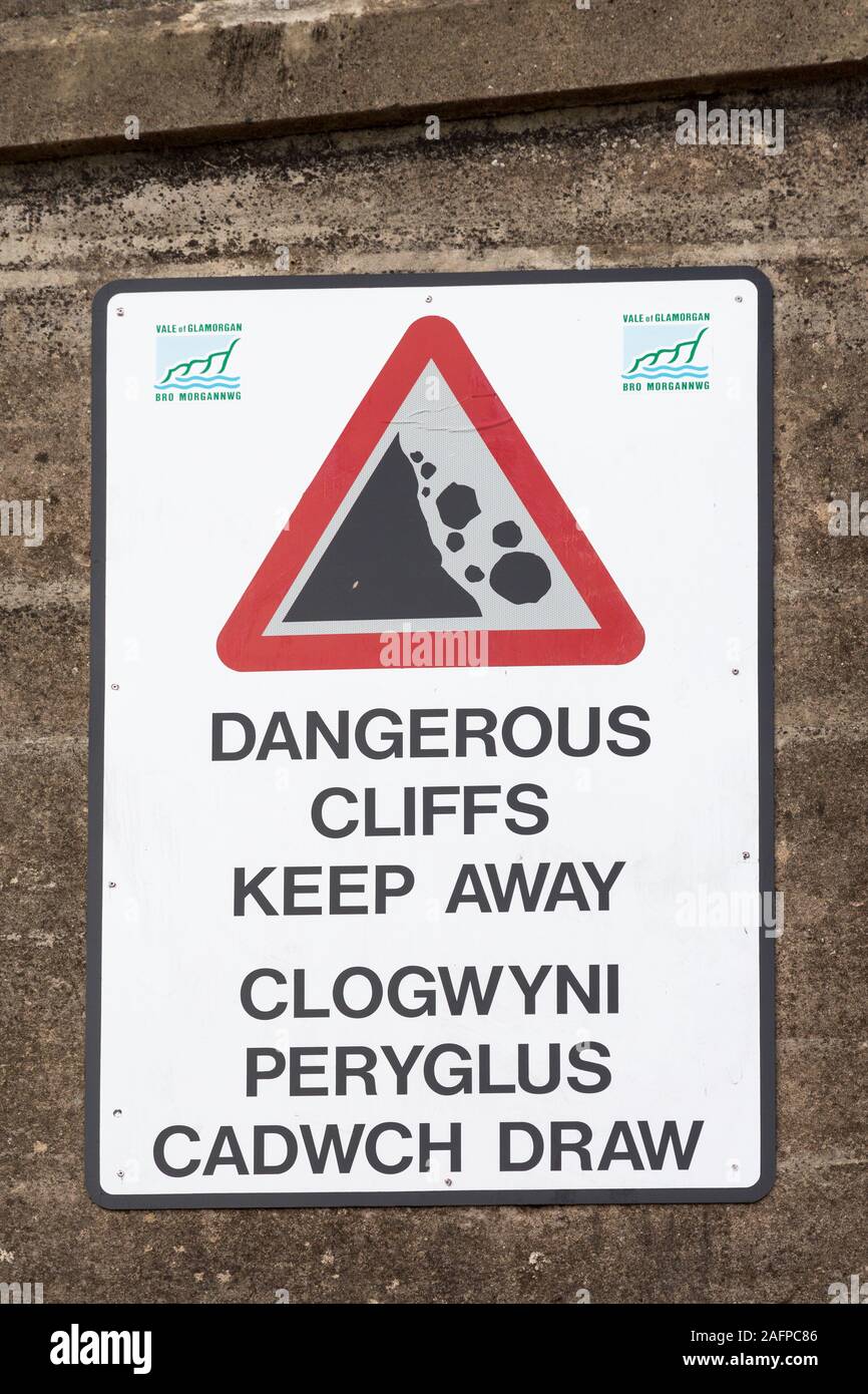 Dangerous cliffs, keep away, sign on sea front in English and Welsh, Penarth, Cardiff, Wales, UK Stock Photo