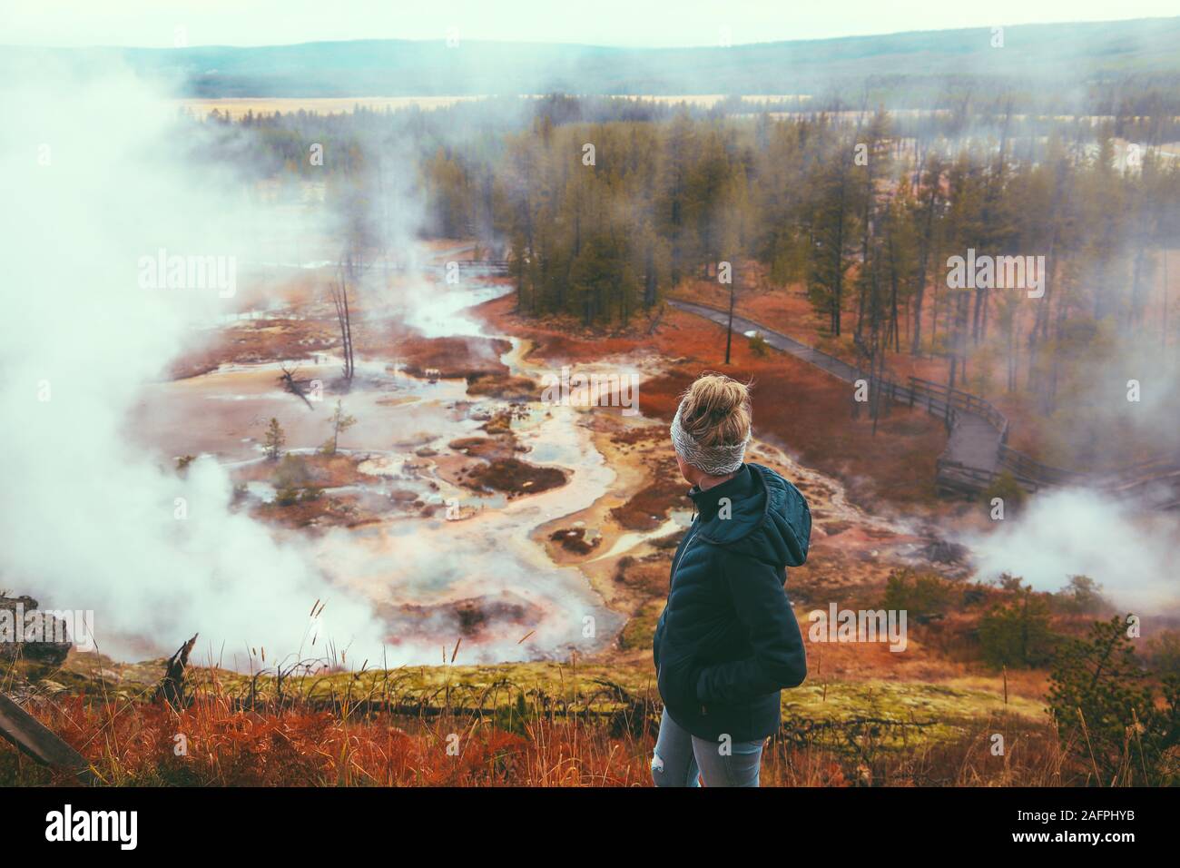 Woman tourist overlooking geyser at Yellowstone National Park Stock Photo