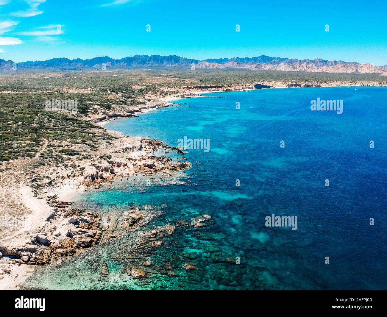 aerial drone view over desert mountains and blue ocean and reef Mexico Stock Photo
