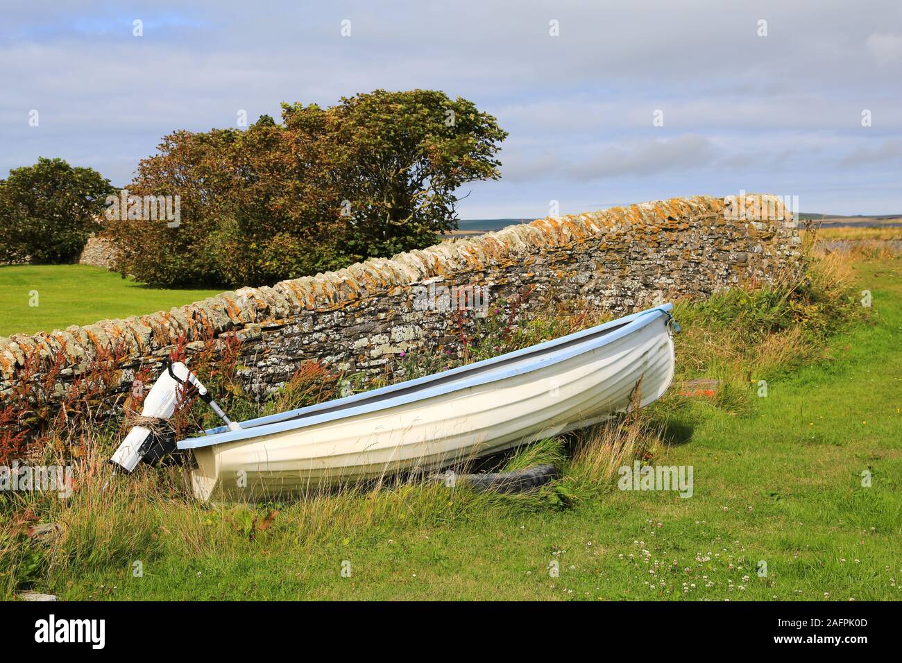 Boat next to stone wall at the Standing Stones Hotel, Stromness, Orkney Islands, United Kingdom Stock Photo