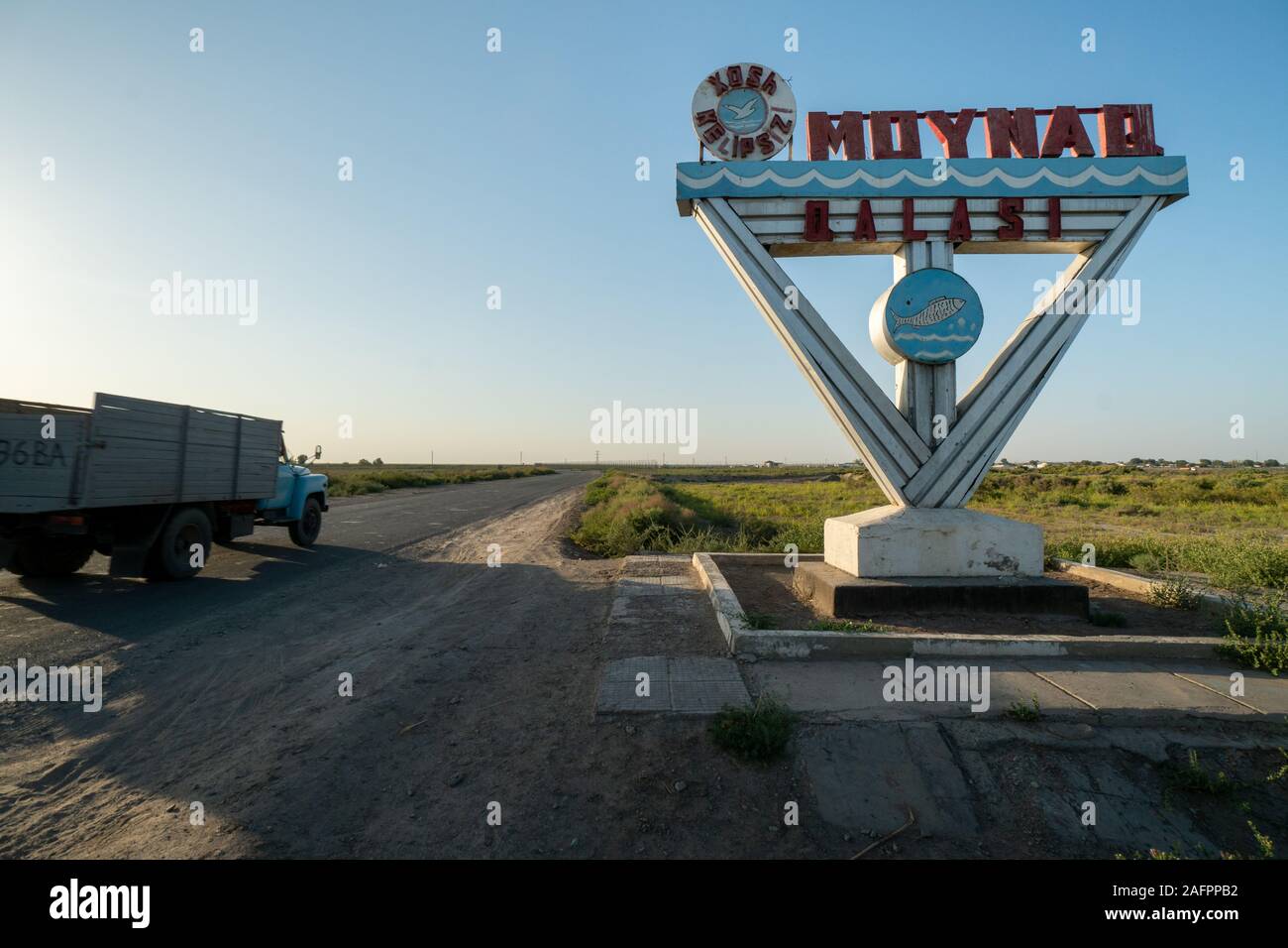 Signpost at the entrance to the tow of Muynak in Uzbekistan (saying 'Moynaq Qalasi' / 'Muynak castle'). It used to be an the shore of the Aral Sea and Stock Photo