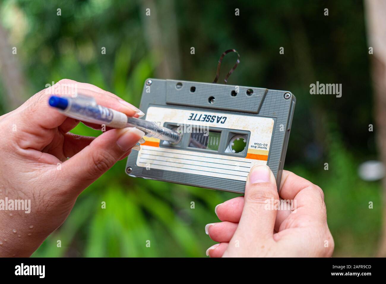 women rewind a cassette tape compact Vintage on blur background, Close up set of old audio tapes, Retro Stock Photo