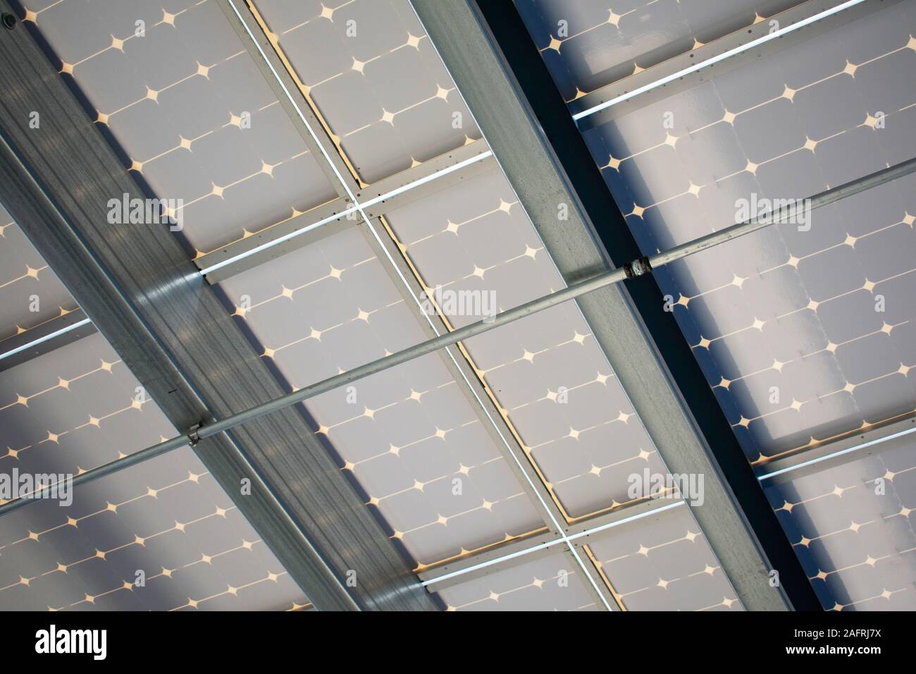 Underside design of a solar panels installed as solar canopy on top of parking garage. Solar panels convert the sun's rays into electricity and provid Stock Photo