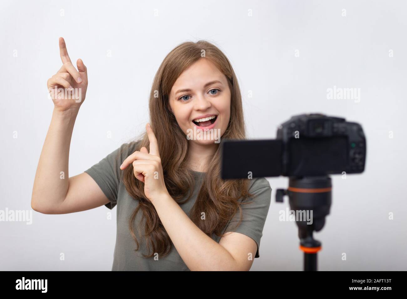 Smiling young caucasian girl woman making a video blog (vlog) with camera Stock Photo