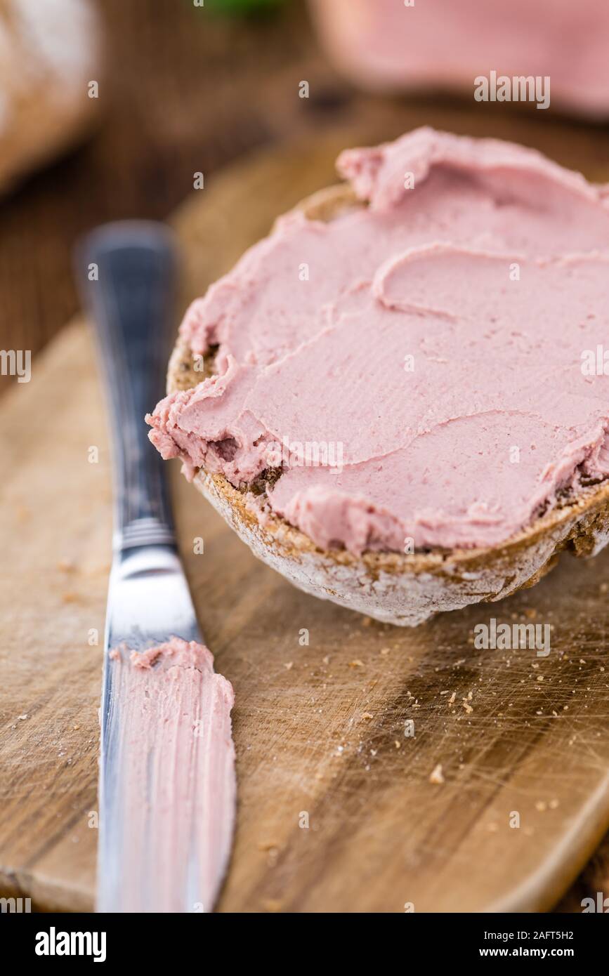 Roll with Liverwurst (German cuisine) on an old wooden table as