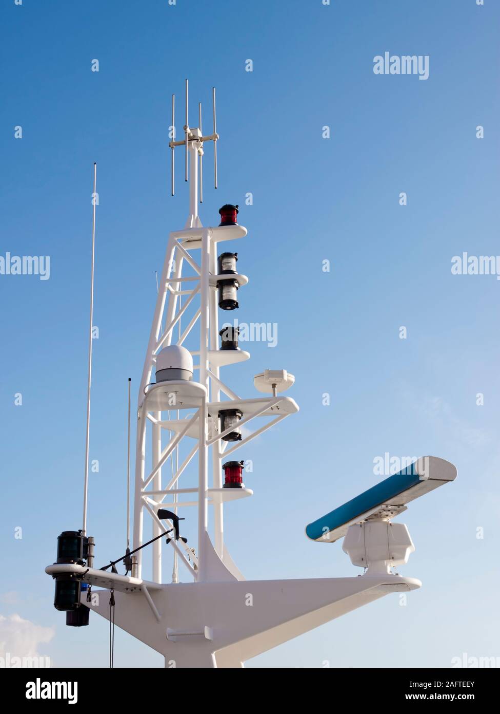 Antennas, radar, anemometer and other communication and navigation equipment on the mast of a ship. Stock Photo