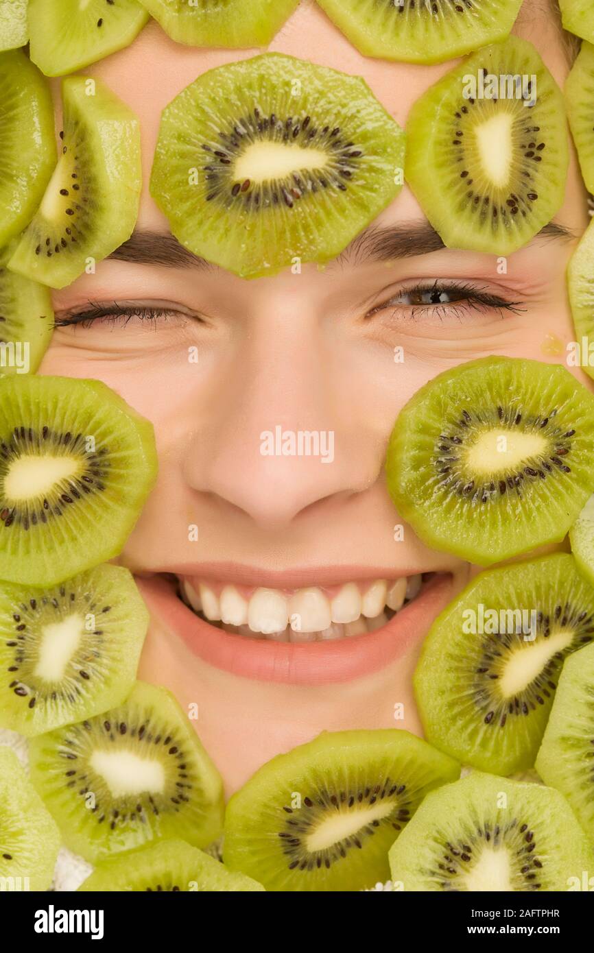 Young beautiful woman posing with slices of kiwi on her face Stock Photo -  Alamy