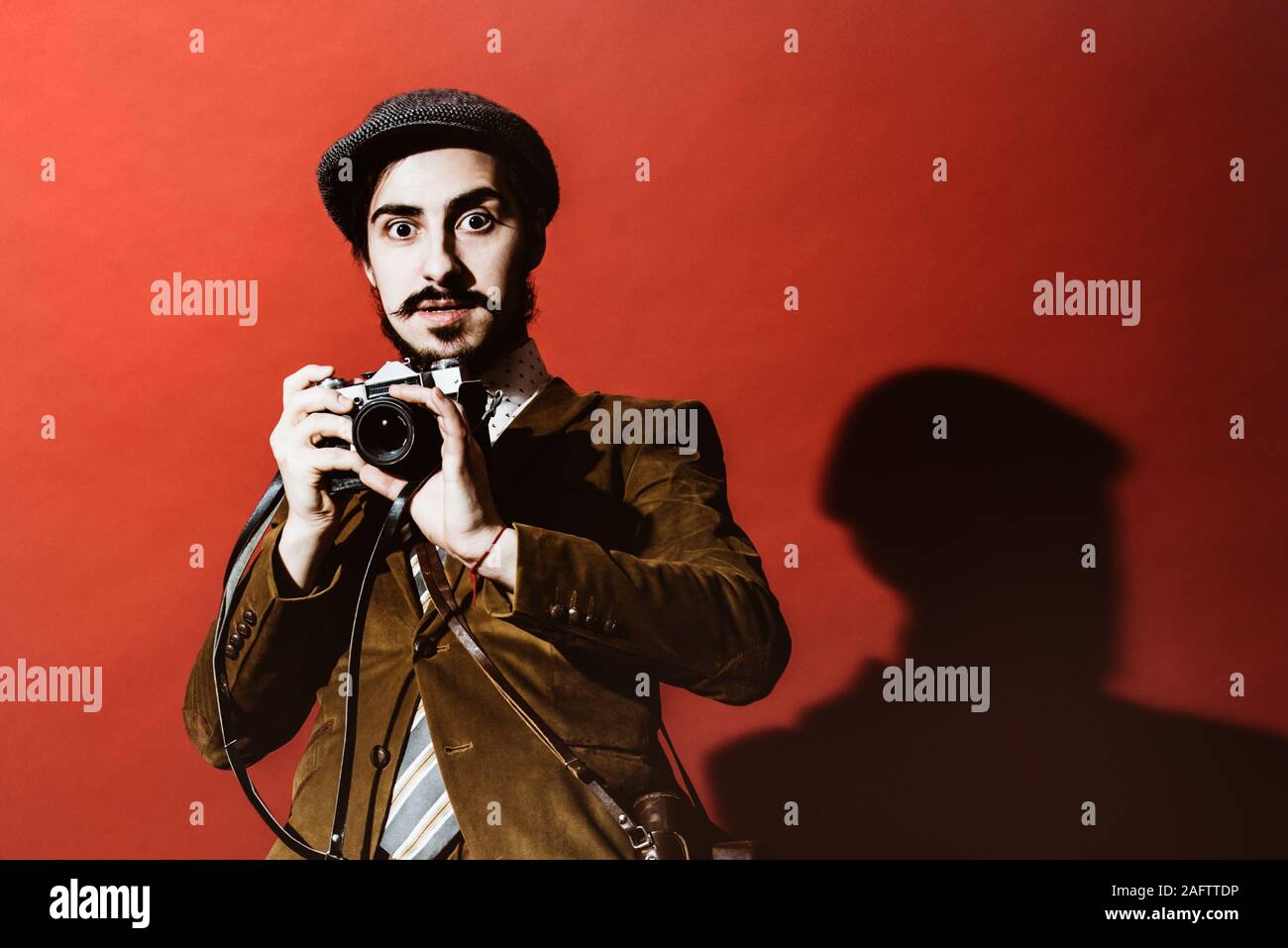 very positive photographer posing in studio with camera Stock Photo
