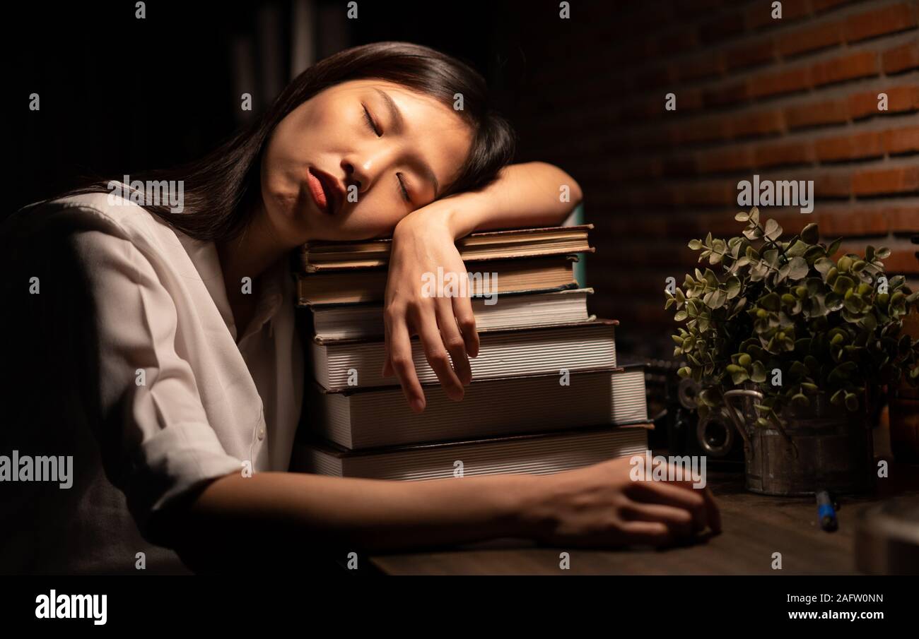 Young Asian girl sleeping be tired by the study Stock Photo