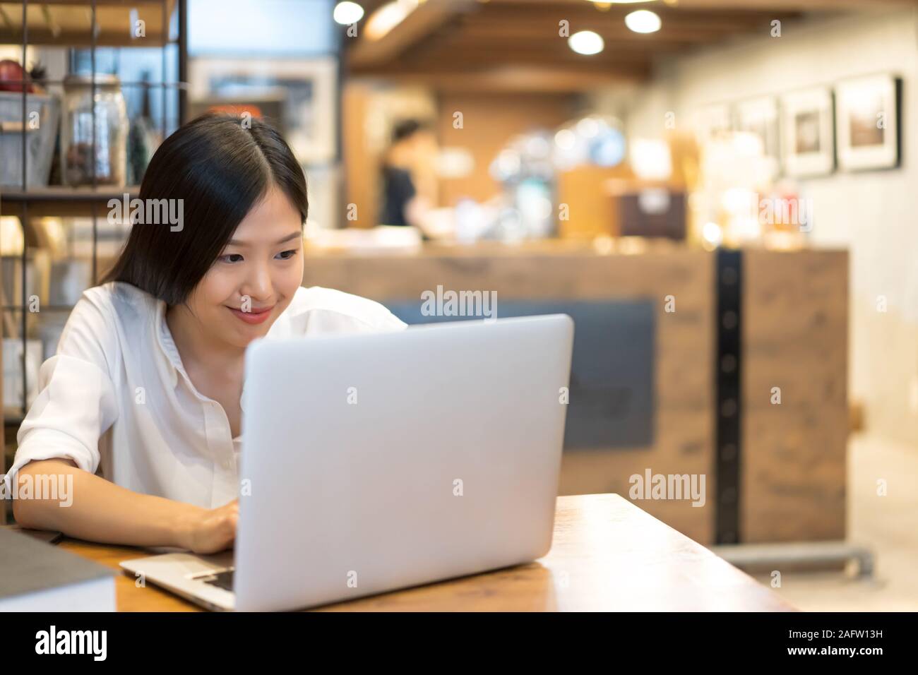 Young Asian woman working with a laptop in the coffee shop cafe office ...