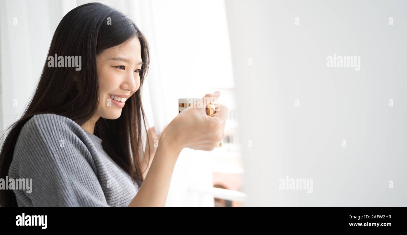 Portrait Asian woman relaxing with coffee at home Stock Photo