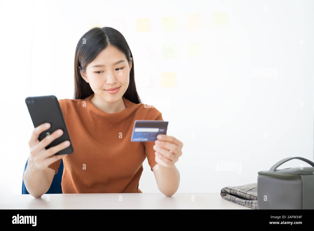 Young Asian woman using smartphone and credit card. Shopping buying online Stock Photo