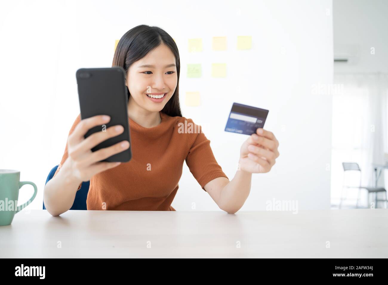 Young Asian woman using smartphone and credit card. Shopping buying online Stock Photo