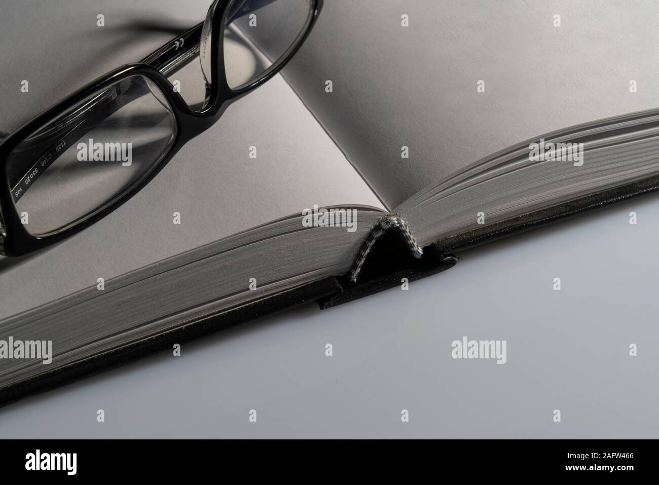 a pair of glasses on the blank pages of a book Stock Photo